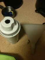 The tools you need: a water filter with the top cut out, a stopper to plug the hole, and a funnel